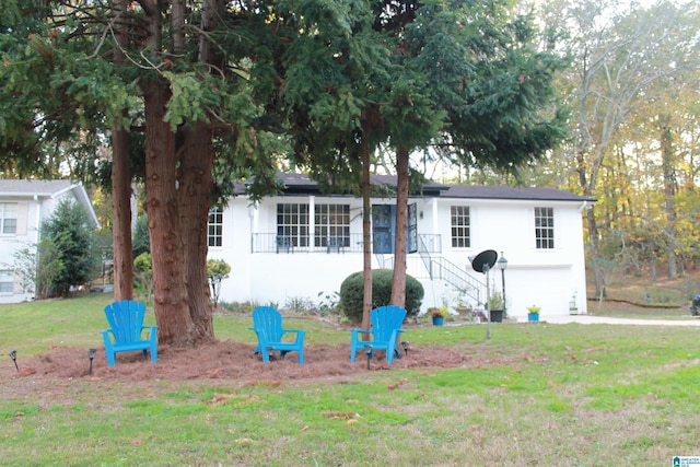 view of front facade with an attached garage, a front lawn, concrete driveway, and stucco siding
