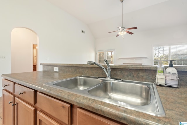 kitchen featuring ceiling fan, sink, and vaulted ceiling