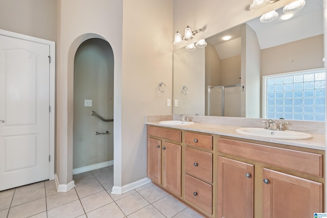 bathroom featuring vanity, vaulted ceiling, tile patterned flooring, and a shower with door