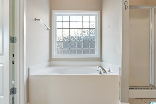 bathroom with tile patterned flooring and separate shower and tub