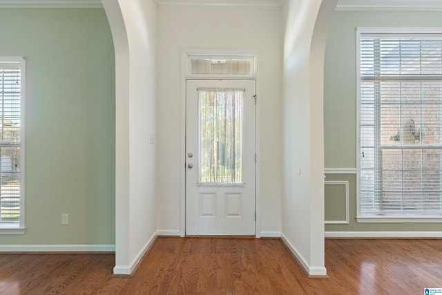 foyer featuring hardwood / wood-style floors, crown molding, and plenty of natural light