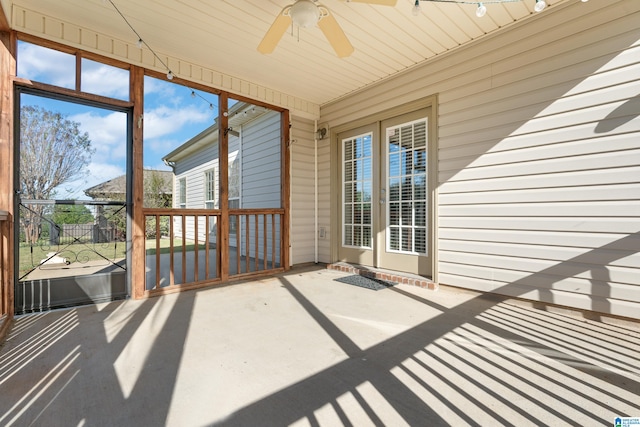 unfurnished sunroom featuring ceiling fan