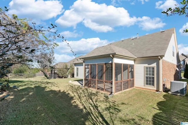 back of house with a sunroom, central AC, and a yard