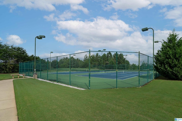 view of tennis court featuring a yard