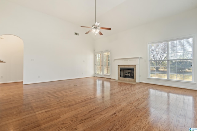 unfurnished living room featuring high vaulted ceiling, light wood-type flooring, and ceiling fan