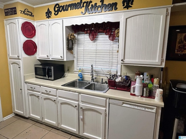 kitchen with dishwasher, sink, light tile patterned floors, ornamental molding, and white cabinetry