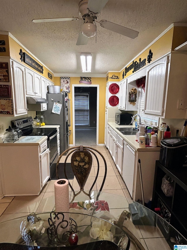 kitchen featuring a textured ceiling, black range with electric cooktop, sink, light tile patterned floors, and white cabinetry