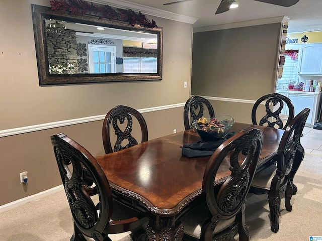 carpeted dining space featuring ceiling fan and ornamental molding