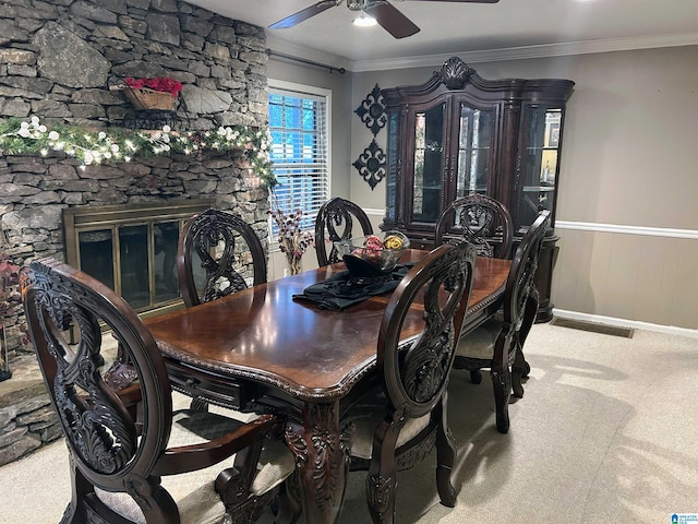 dining room featuring a fireplace, carpet floors, ceiling fan, and crown molding