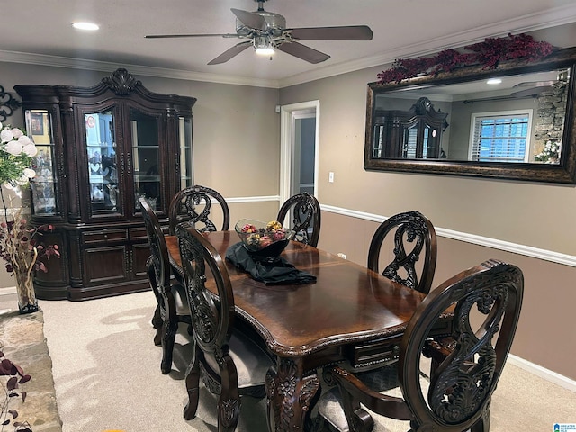 carpeted dining area featuring crown molding and ceiling fan