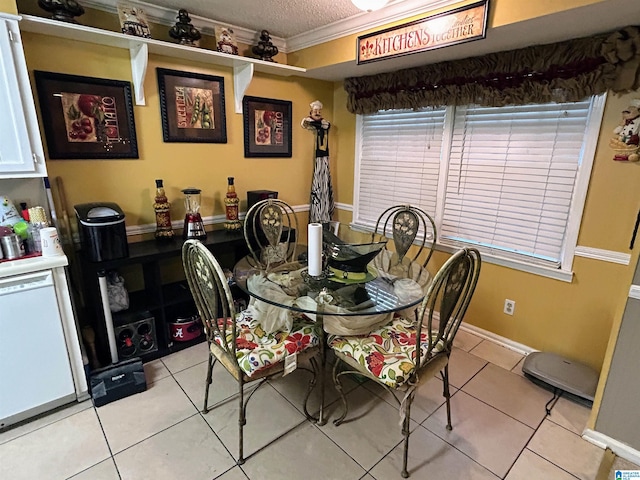 tiled dining room featuring a textured ceiling and ornamental molding