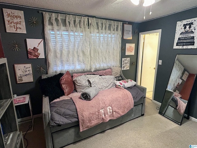 bedroom with ceiling fan, carpet floors, and a textured ceiling