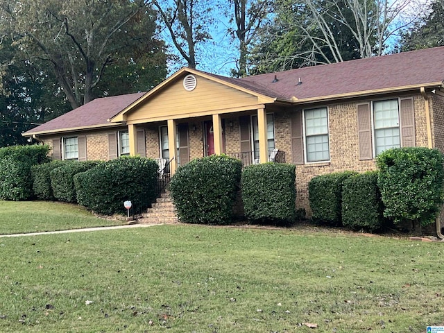 ranch-style home with covered porch and a front yard