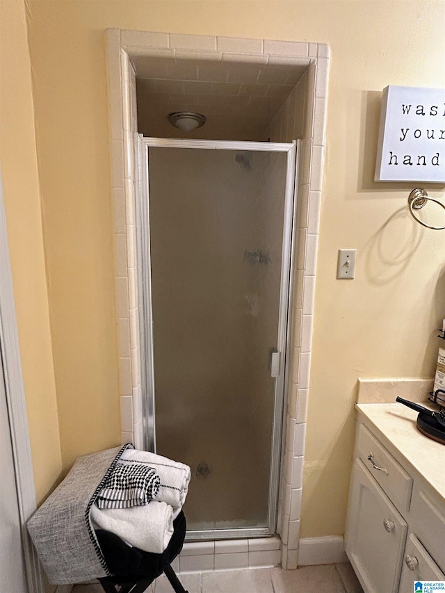 bathroom featuring tile patterned flooring, vanity, and a shower with shower door