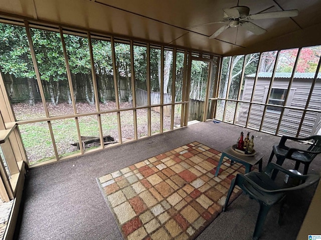 unfurnished sunroom with ceiling fan