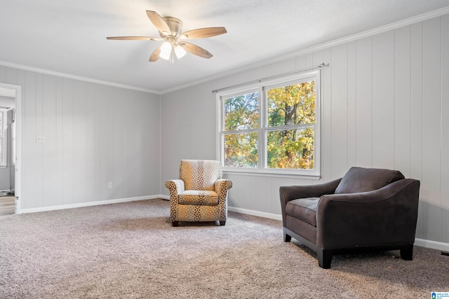 living area featuring carpet, ceiling fan, crown molding, and wood walls