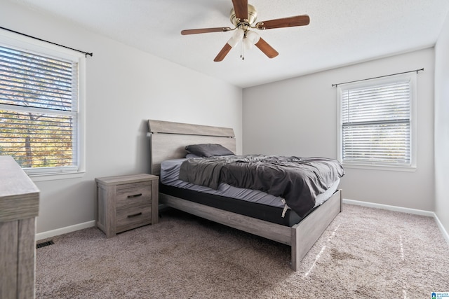 bedroom with a textured ceiling, light colored carpet, and ceiling fan