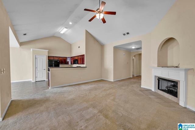 unfurnished living room with ceiling fan, high vaulted ceiling, and light carpet