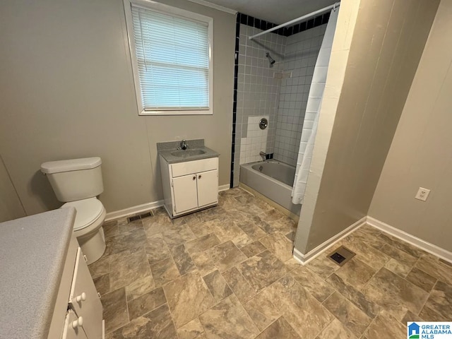 full bathroom with vanity, tiled shower / bath combo, and toilet