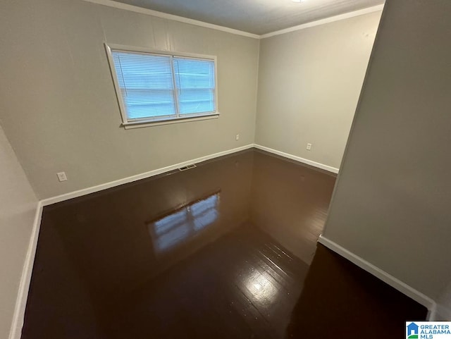 empty room featuring dark hardwood / wood-style floors and ornamental molding