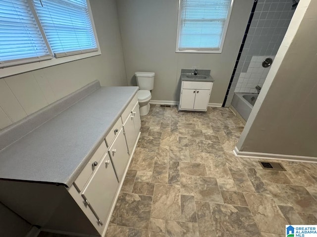 full bathroom featuring vanity, plenty of natural light, toilet, and tiled shower / bath combo