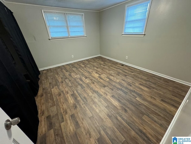 unfurnished room featuring ornamental molding and dark hardwood / wood-style flooring