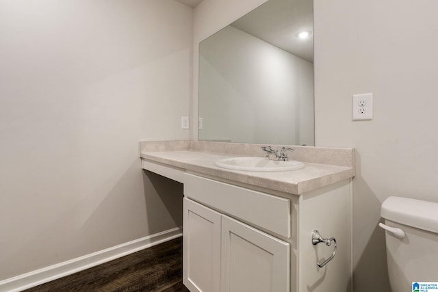 bathroom featuring wood-type flooring, toilet, and vanity