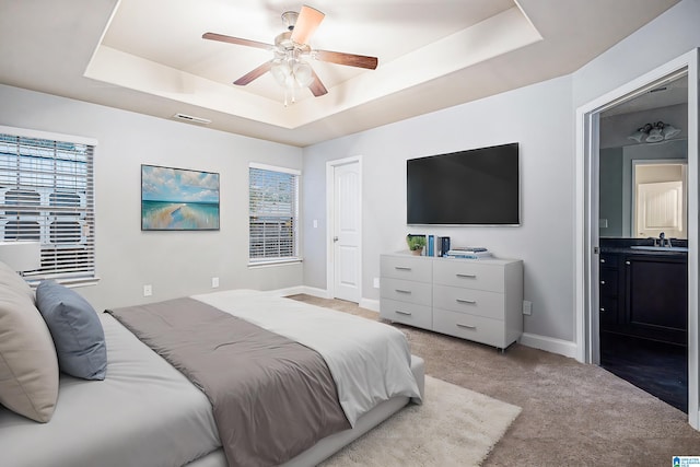 bedroom featuring carpet flooring, a raised ceiling, ceiling fan, and sink