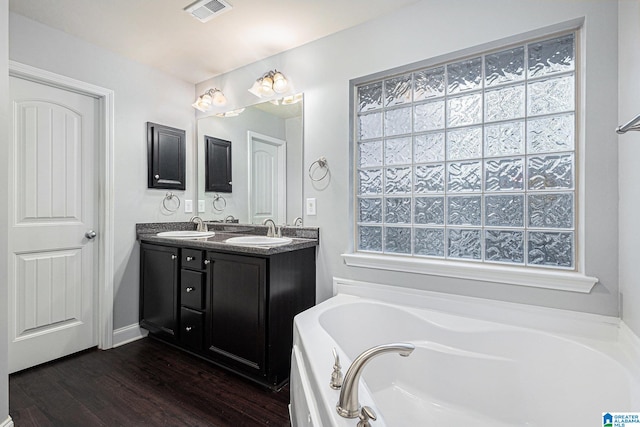 bathroom with a tub to relax in, vanity, and hardwood / wood-style flooring