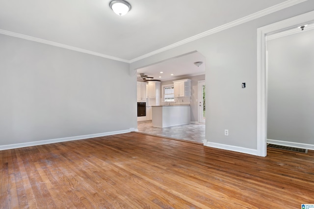 unfurnished living room featuring crown molding and light hardwood / wood-style flooring