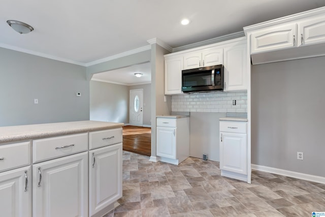 kitchen featuring decorative backsplash, white cabinetry, and ornamental molding