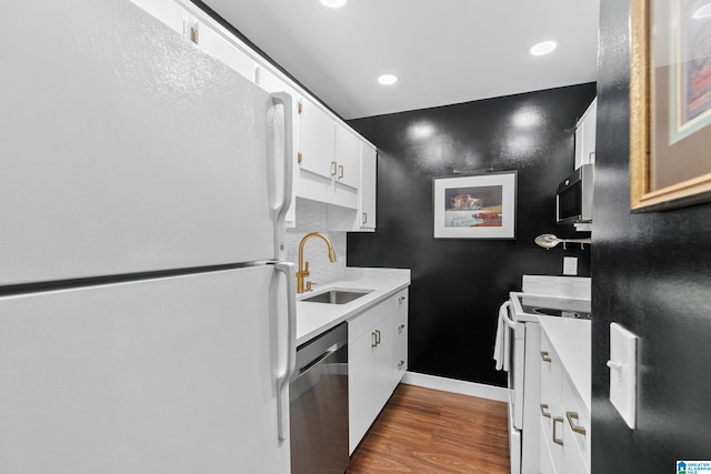 kitchen with stainless steel appliances, backsplash, dark hardwood / wood-style flooring, sink, and white cabinets