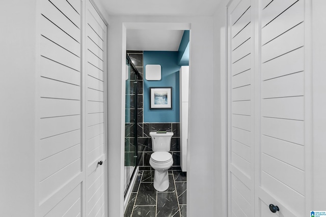 bathroom with toilet and tile walls