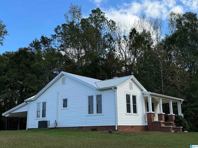 view of front of property with a porch, central AC, a front yard, and a carport