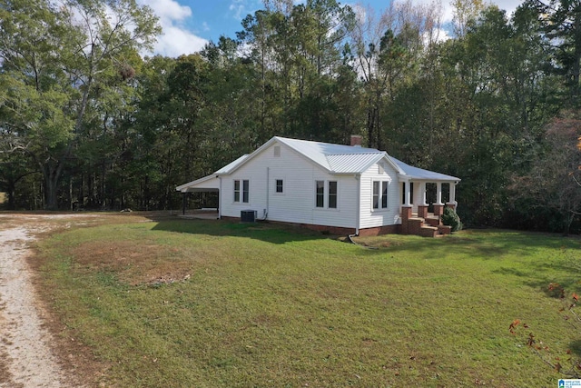 view of front facade with central air condition unit, a carport, and a front lawn