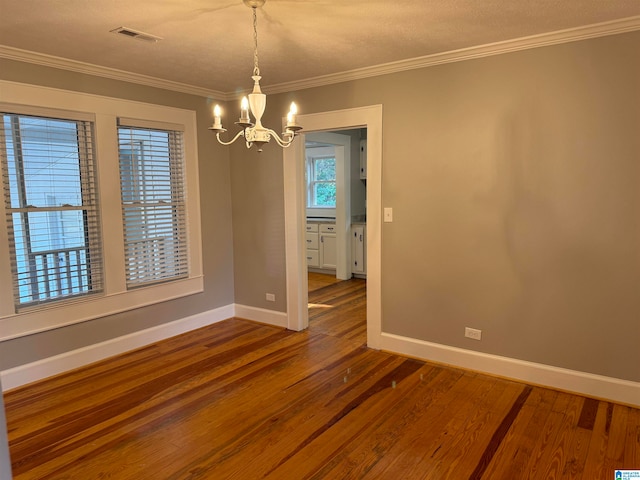 spare room with wood-type flooring, plenty of natural light, and ornamental molding