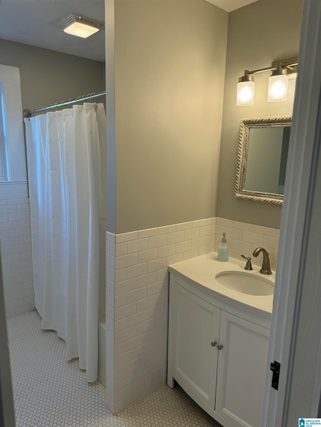 bathroom featuring vanity, tile patterned flooring, and tile walls