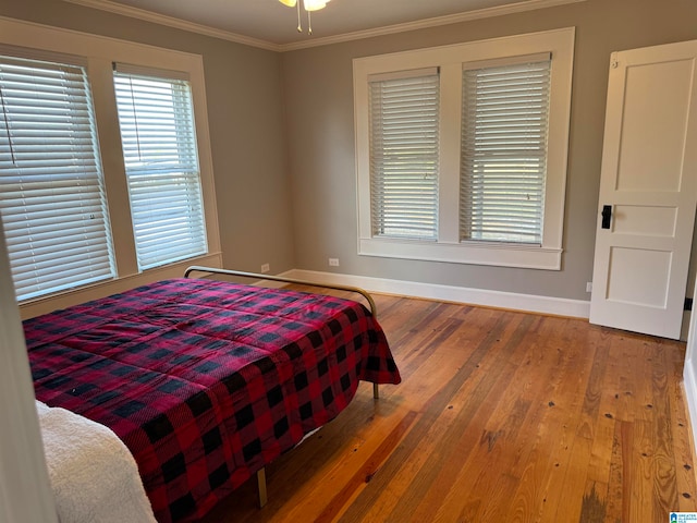 bedroom with wood-type flooring and crown molding