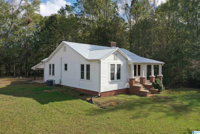 view of front of house with central AC and a front lawn