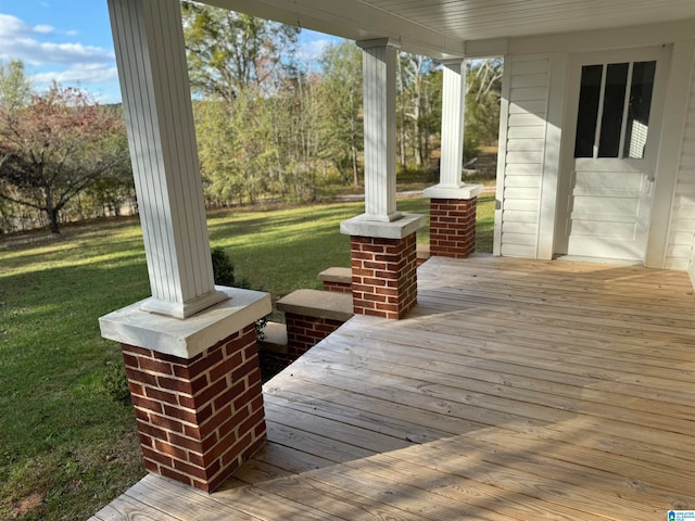 wooden deck with a lawn and covered porch