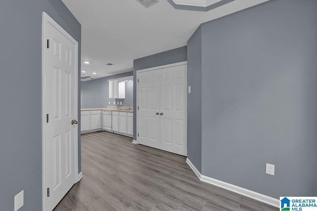 hallway with sink and light hardwood / wood-style floors