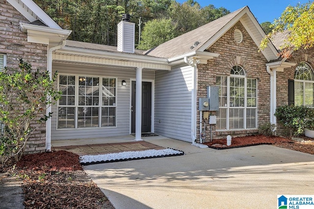 view of exterior entry featuring covered porch