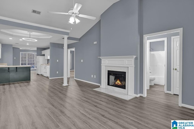 unfurnished living room featuring light hardwood / wood-style flooring, ceiling fan, and crown molding