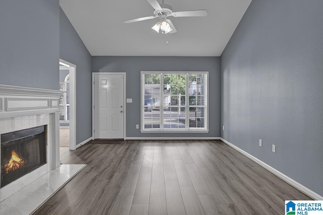 unfurnished living room featuring lofted ceiling, hardwood / wood-style flooring, and ceiling fan