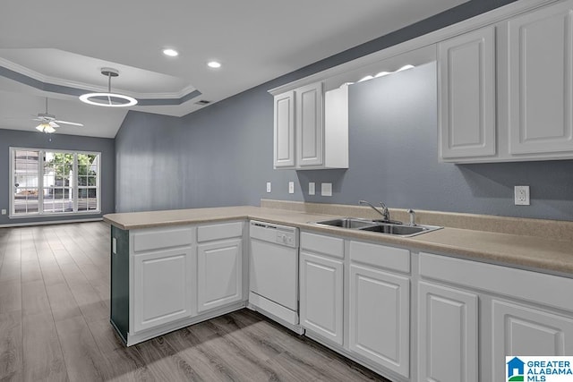 kitchen featuring white dishwasher, white cabinets, sink, and kitchen peninsula