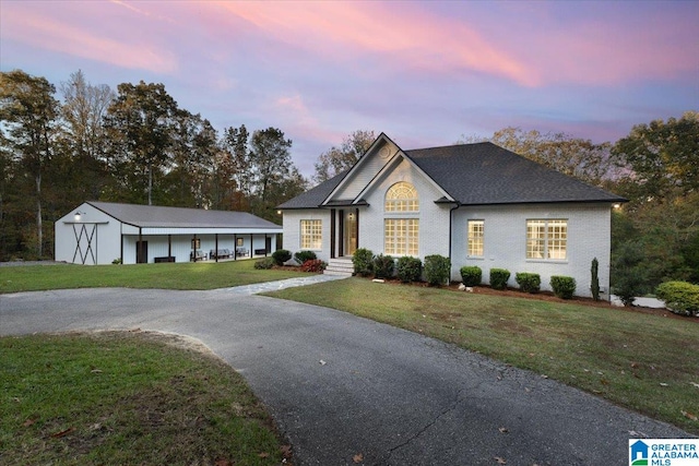 view of front of property featuring an outbuilding, a garage, and a yard