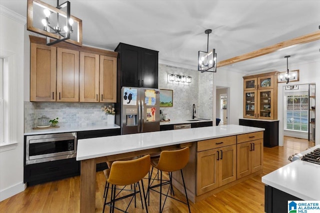 kitchen featuring a center island, hanging light fixtures, light hardwood / wood-style floors, and stainless steel appliances