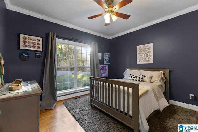 bedroom with ceiling fan, ornamental molding, and wood-type flooring