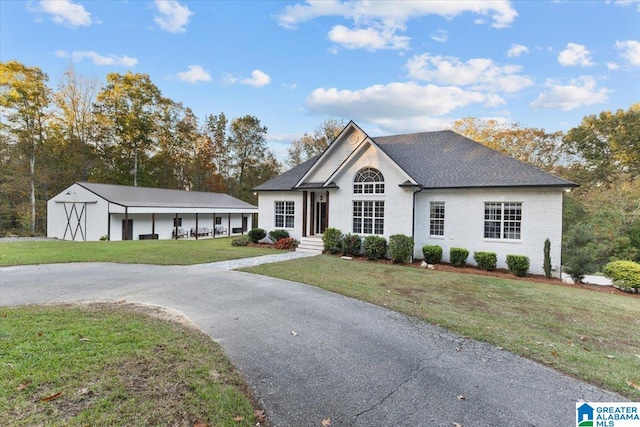 single story home featuring a front yard and an outdoor structure