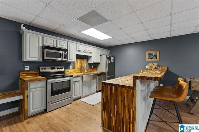 370 Pats Way, Springville, AL 35146 - kitchen featuring butcher block countertops, appliances with stainless steel finishes, a sink, a kitchen breakfast bar, and a drop ceiling